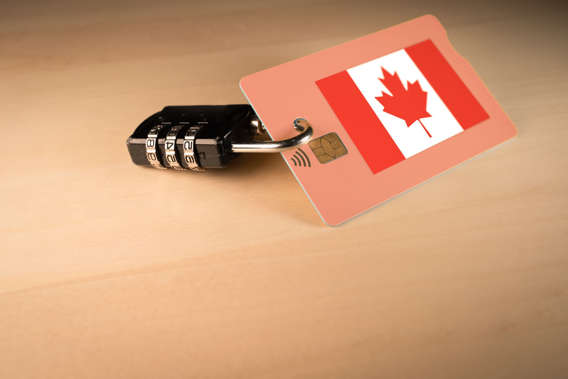 Padlock closed around a credit card with Canadian flag